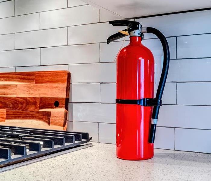 A fire extinguisher sits on a kitchen counter.