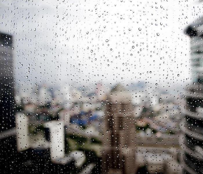 A view of the city is obstructed by a rain-covered window