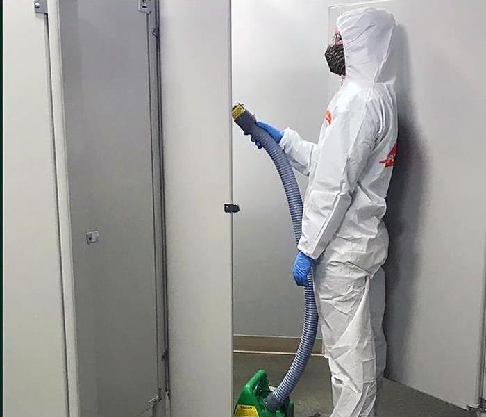 A worker in PPE fogs the bathroom as part of a COVID-19 cleaning in Oxford, MS